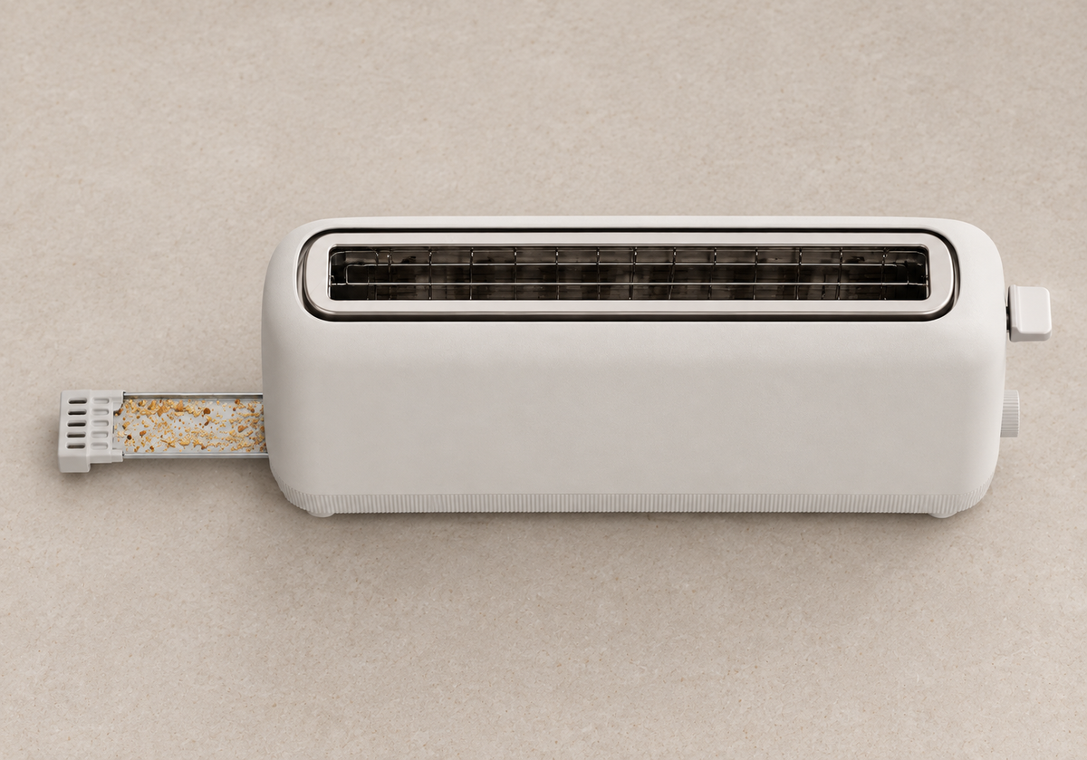 Removable crumb tray partly extended from the non-control end of the toaster.